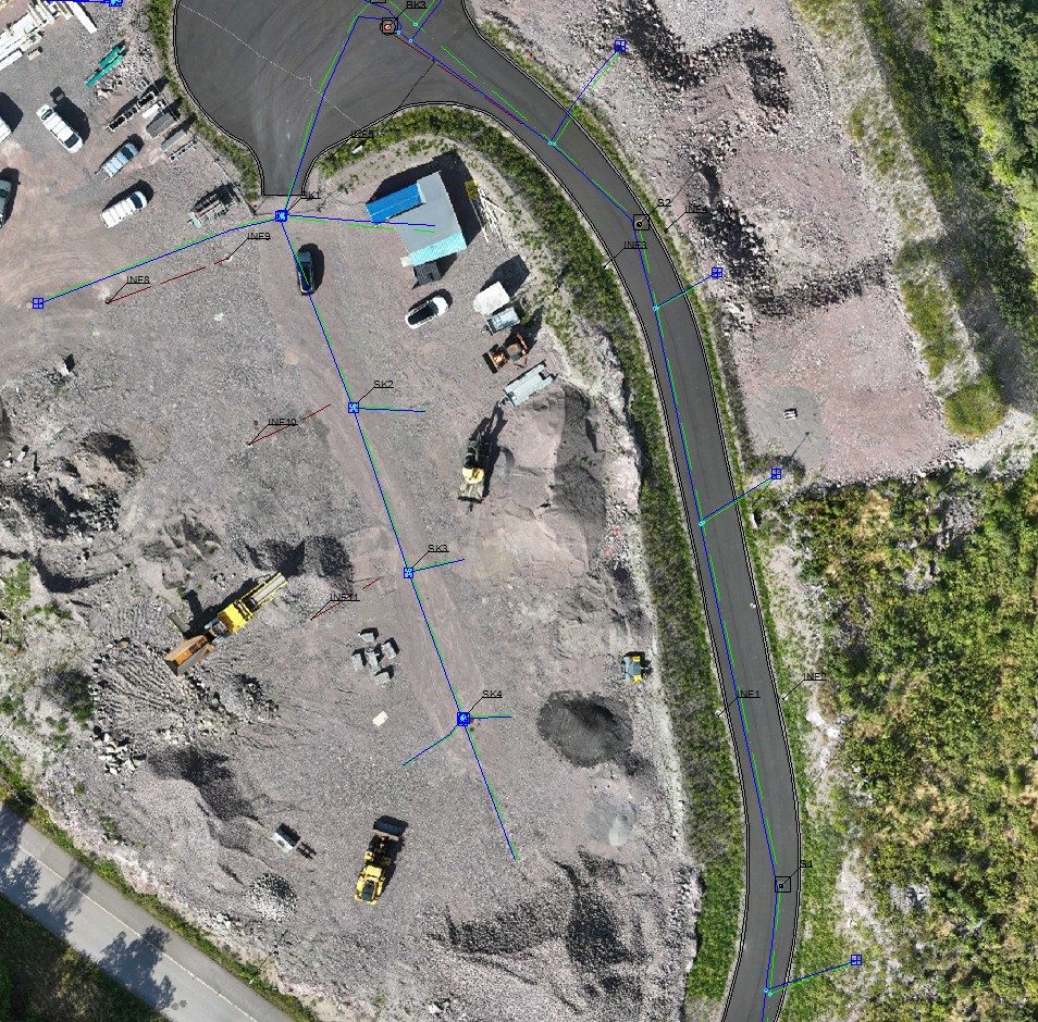 Ortofoto av et anleggsområde med innmålte ledningstraseer og kummer tegnet inn
